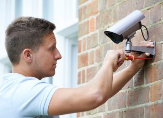 man installing best outdoor wireless security camera system with dvr