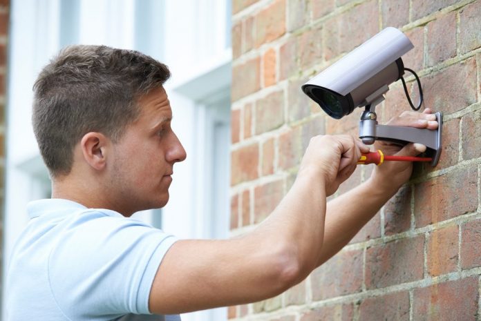 man installing best outdoor wireless security camera system with dvr