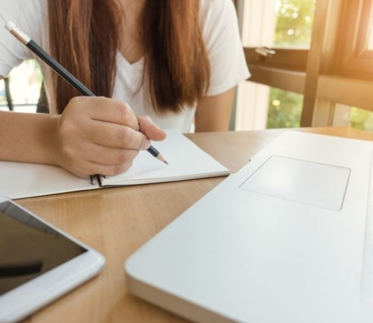 table with laptop and and person study